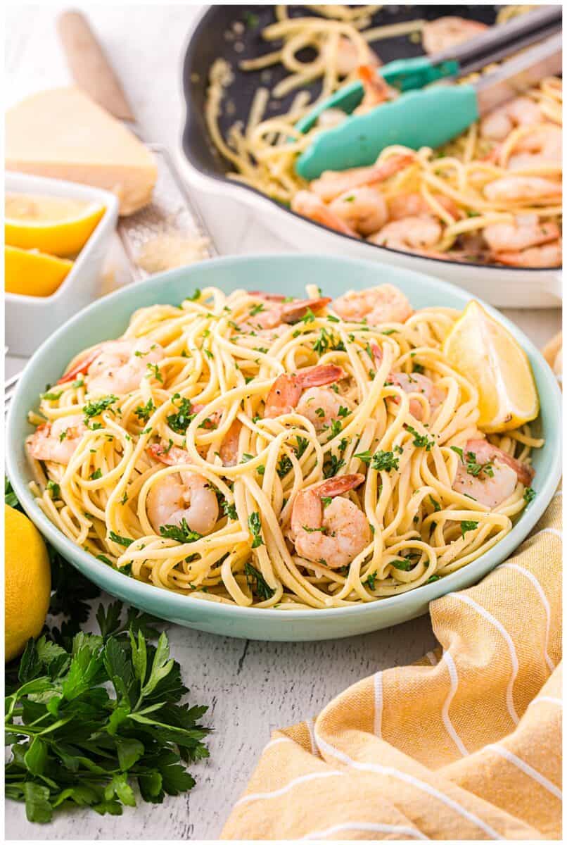 Bowl of shrimp linguine with lemon wedges ready to serve